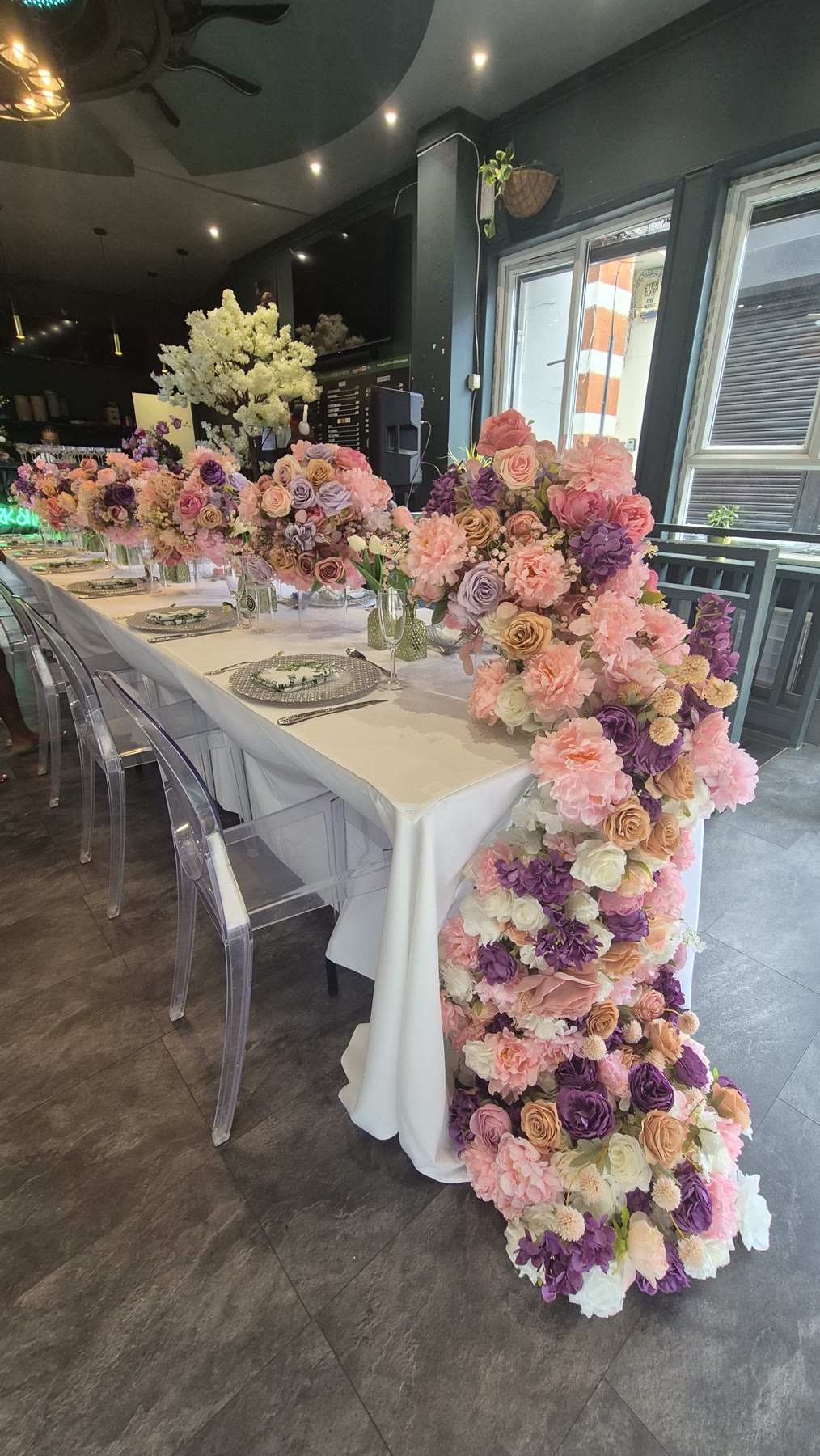 Long private dining table with cascading floral arrangements